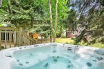 Relax in the private hot tub overlooking the trees at Beach Glass